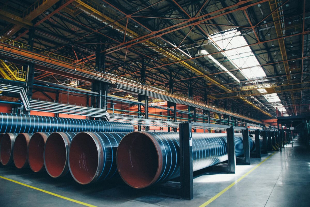 heavy industry concept, construction machinery - long metal pipes inside a large room. Building materials in the hangar